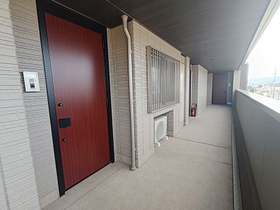 兵庫県西宮市小松東にあるレーヴェ小松東を紹介します。風が気持ちよい廊下に、玄関ドアは高級感のある暖色のドアを採用しています。